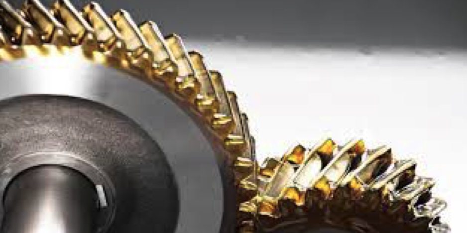 Close-up of lubricated gear teeth meshing